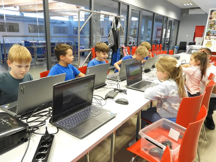 Uczestnicy pracują przy laptopach